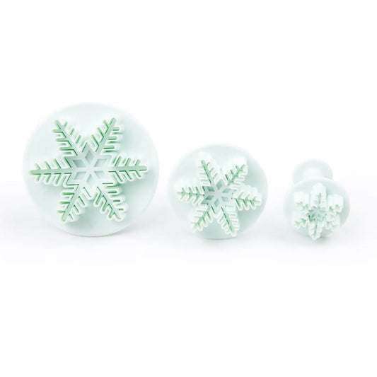 Three-piece snowflake plunger cutter set in graduated sizes, ideal for fondant, gum paste, and holiday cookie decorating.