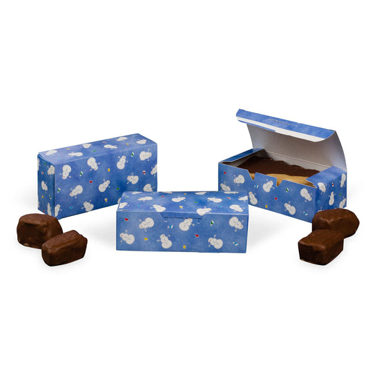 Blue Snowman Avalanche candy boxes shown closed and open, featuring a repeating snowman pattern with small colorful confetti dots and assorted chocolates nearby.