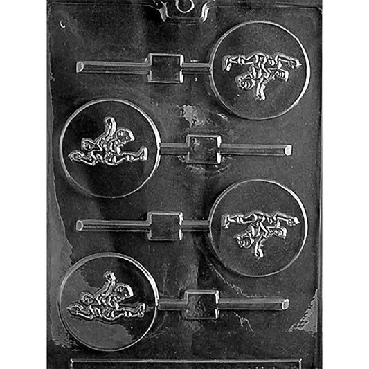 Clear plastic chocolate lollipop mold with four round cavities, each showing a raised soccer player kicking a ball, with stick channels on a dark background.
