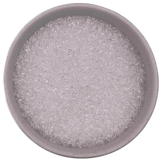 Top-down view of a round container filled with sparkling white coarse sanding sugar crystals, showing clear, chunky granules packed closely together.