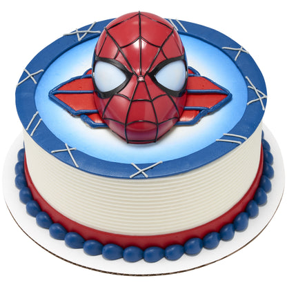 Spider-Man head topper placed on a round blue cake with web-style accents.