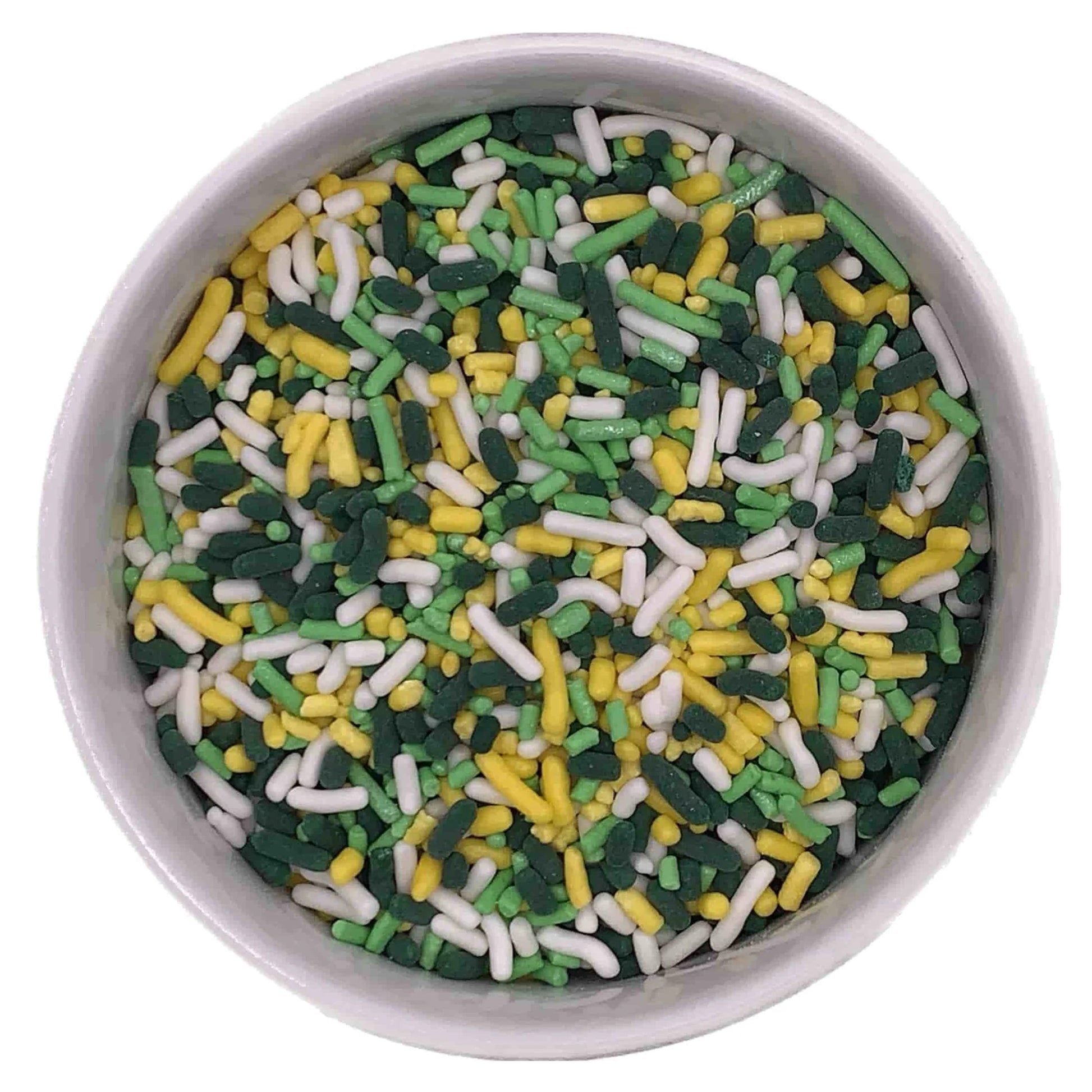 Overhead close-up of a white bowl filled with jimmies sprinkles in dark green, light green, yellow, and white for St. Patrick’s Day decorating.
