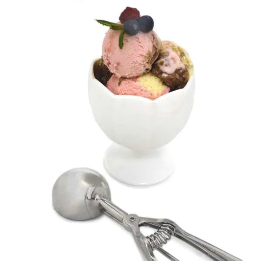 Stainless steel scoop beside a white bowl filled with colorful ice cream scoops topped with berries and mint, illustrating scoop size and use