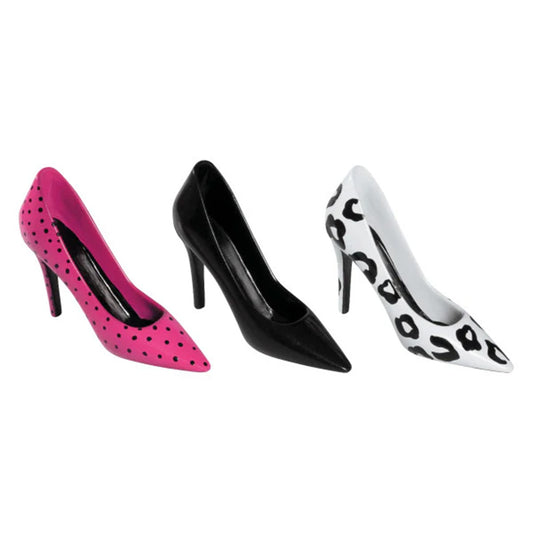 Three stiletto high heel cake toppers shown side by side: a hot pink heel with black polka dots, a solid black heel, and a white heel with black leopard-style spots on a white background.