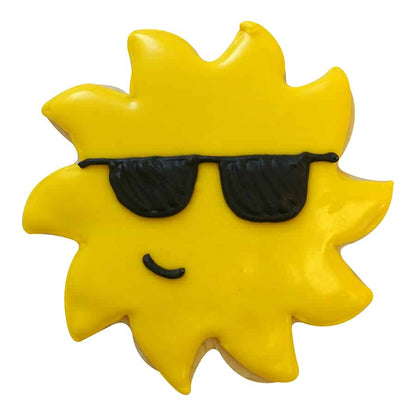 Decorated sun-shaped cookie with yellow icing, black sunglasses, and a smiling face.