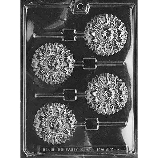 Clear plastic chocolate lollipop mold photographed on a black background with four sunflower-shaped cavities, each with detailed petals, textured centers, and stick channels.