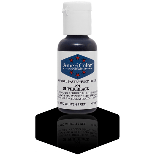 A bottle of AmeriColor Super Black soft gel paste food coloring, featuring a white cap and blue label with red stars, standing on a glossy black surface with its reflection visible.
