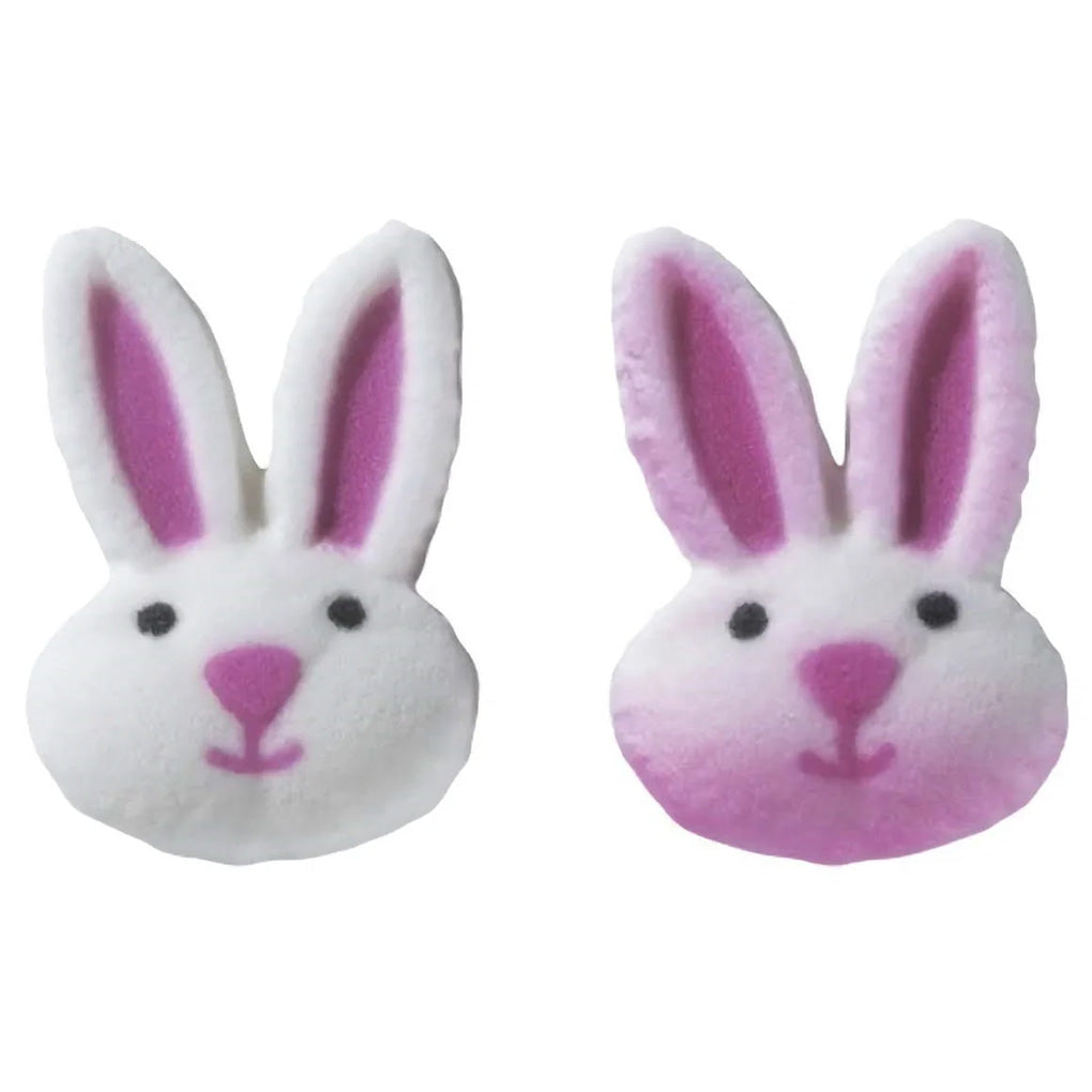 Pink and white pressed sugar bunny face cake decorations with long ears, black eyes, pink noses, and hand-painted facial details.