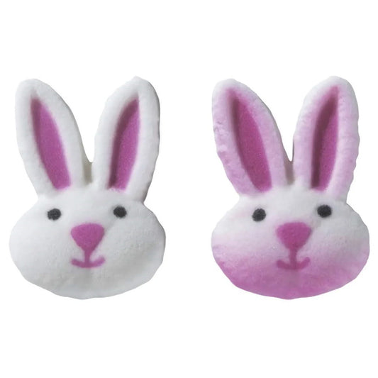 Pink and white pressed sugar bunny face cake decorations with long ears, black eyes, pink noses, and hand-painted facial details.