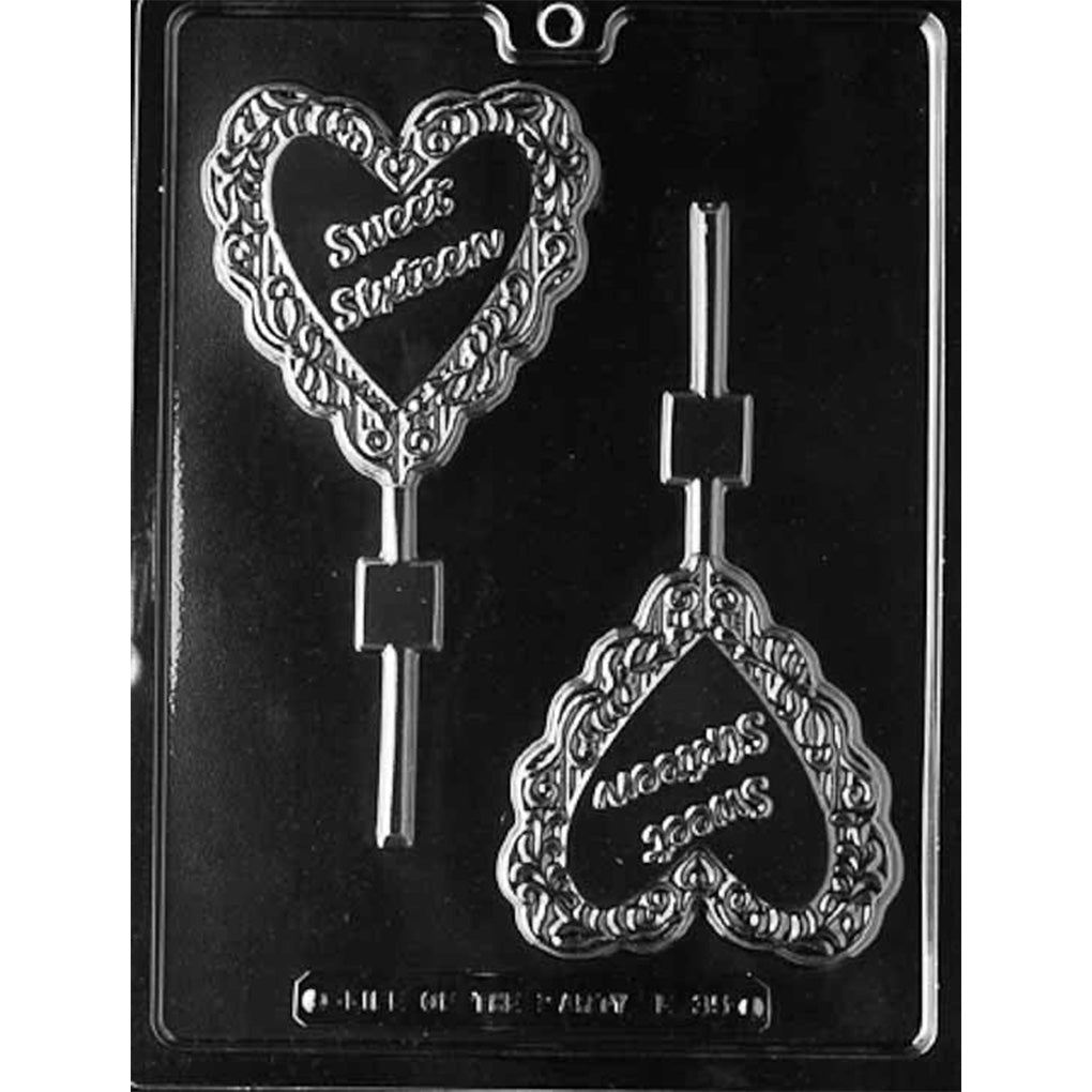 Clear Sweet Sixteen Chocolate Lollipop Mold photographed against a black background with two ornate heart-shaped lollipop cavities featuring raised Sweet Sixteen lettering and built-in stick channels.