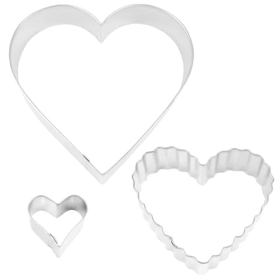 Three heart-shaped metal cookie cutters in different sizes, including a fluted-edge heart and a classic heart, displayed on a white background.