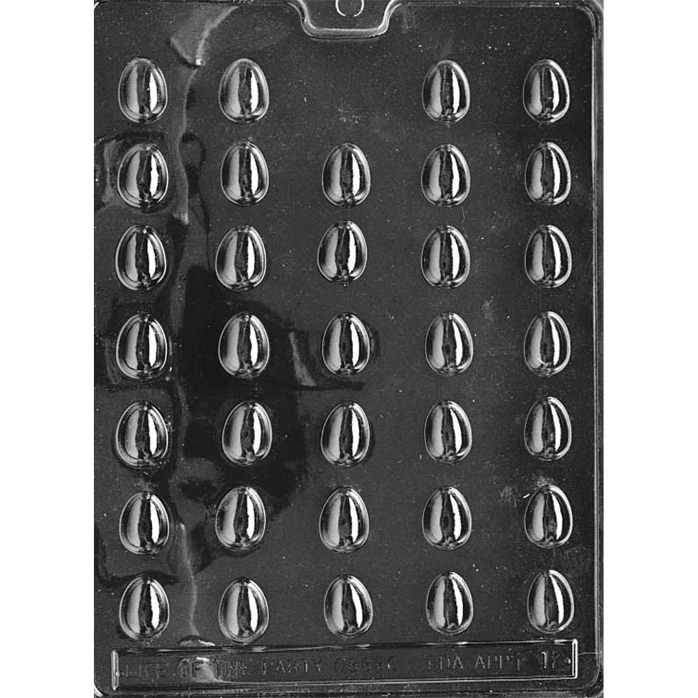 Clear plastic tiny Easter egg chocolate mold shown on a black background, with many small egg-shaped cavities arranged in a grid and a defined center ridge on each egg.