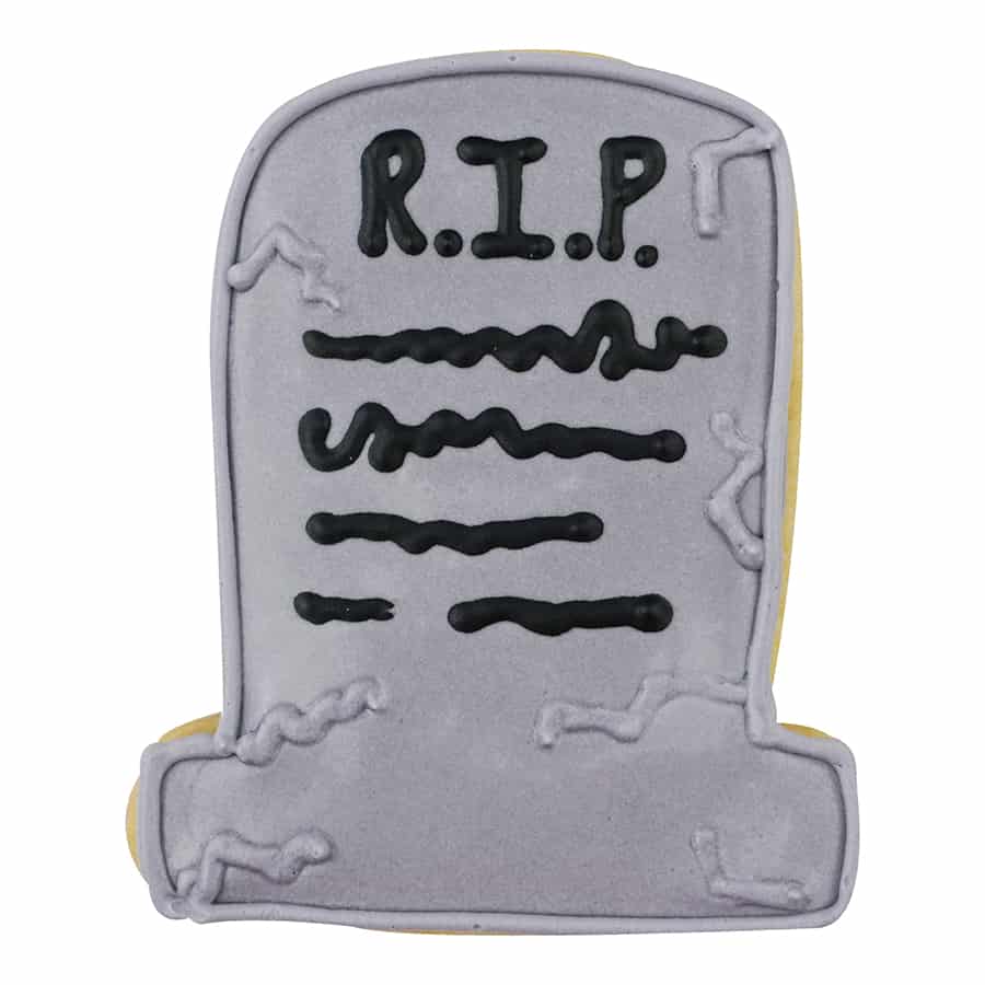 Decorated tombstone-shaped cookie with a gray icing base, black "R.I.P." text, and spooky detailing.