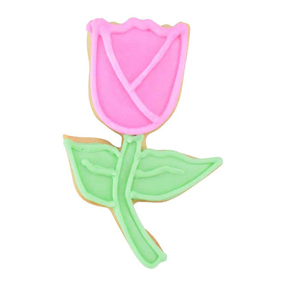 Decorated tulip cookie with pink icing on the bloom and green icing on the stem and leaves, showcasing intricate piping details.