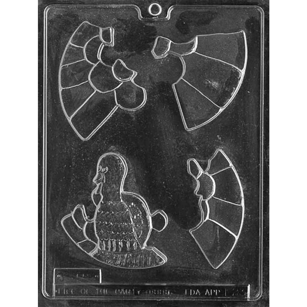 Clear plastic chocolate mold with several interlocking puzzle-style cavities that assemble into a cartoon turkey, including curved tail feather sections and a turkey body piece.
