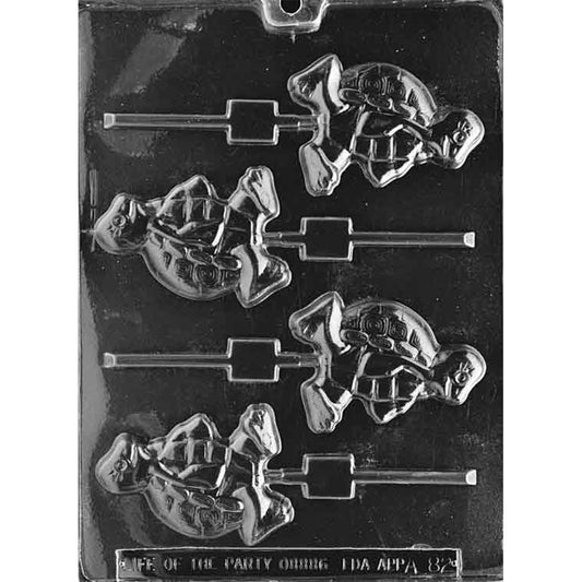 Clear plastic chocolate lollipop mold photographed on a dark background with four turtle character cavities, each showing a two-foot walking pose, segmented shell pattern, and a stick channel.