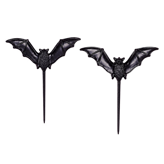 Two dark vampire bat cupcake picks with wide outstretched wings and long stems displayed against a white background.