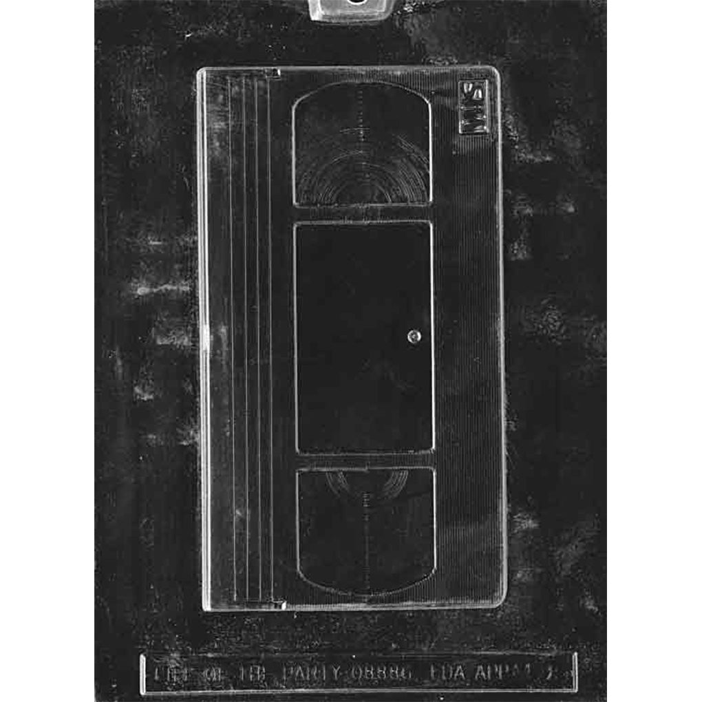 Single-cavity VHS cassette chocolate mold with two reel windows and center label panel, measuring approximately 7 1/4 x 4 1/8 x 1/2 inches deep