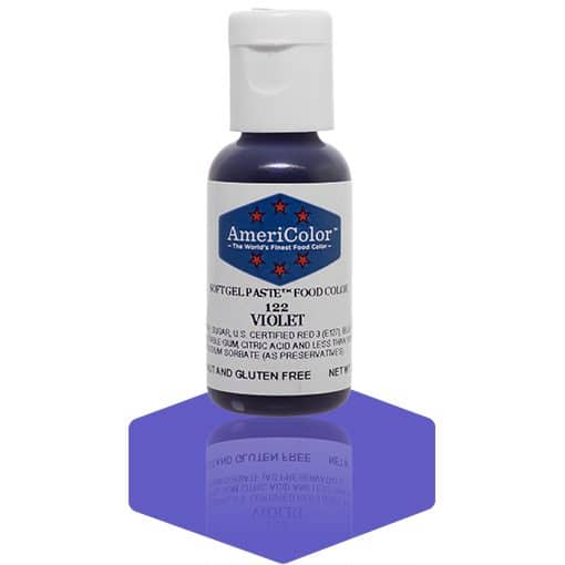 A bottle of AmeriColor Violet soft gel paste food coloring with a white cap, blue label, and red stars, placed on a purple reflective surface with the bottle’s reflection clearly visible.