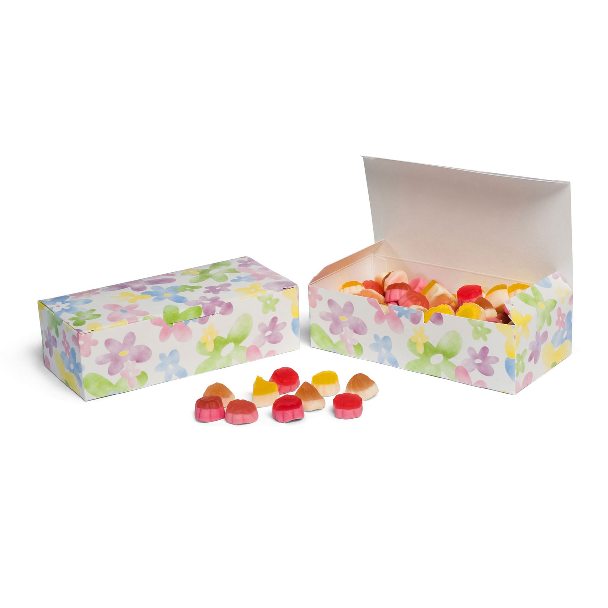 Watercolor daisy candy boxes, one closed and one open and filled with assorted pastel candies, with candies placed in front.