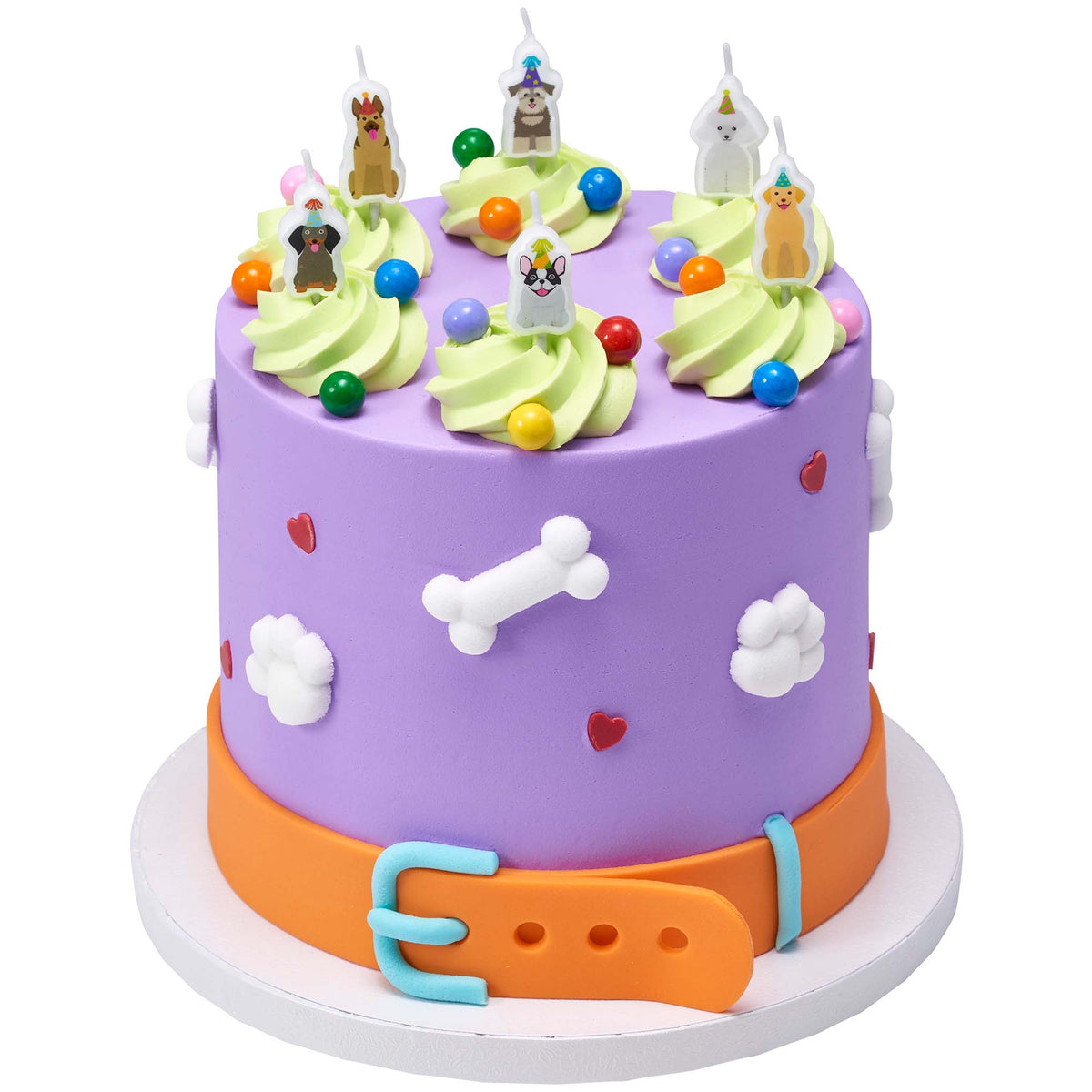Purple dog-themed cake decorated with white dog bone and paw-shaped pressed sugars, green frosting swirls, colorful candy balls, and dog candles.