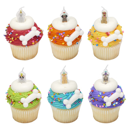 Six colorful sprinkle cupcakes decorated with white dog bone pressed sugars, white icing rings, and assorted dog-themed birthday candles.