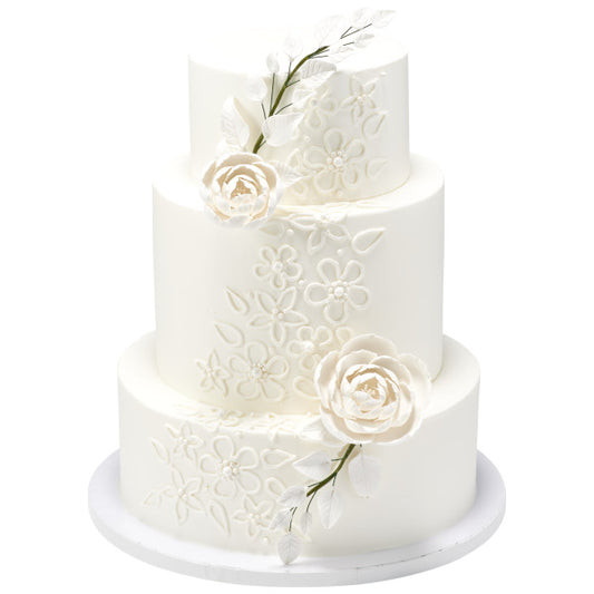 Three-tier white wedding cake decorated with embossed floral pattern and white gum paste briar roses