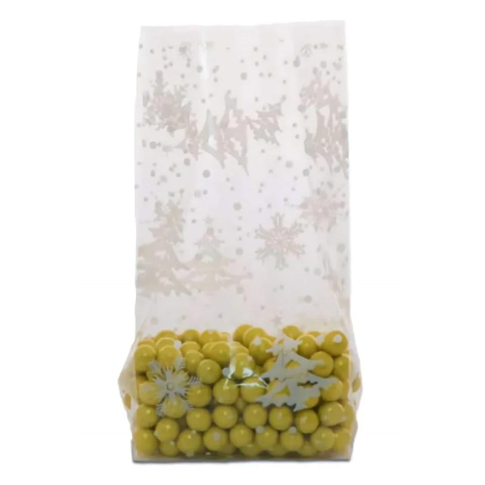 Clear medium cello treat bag with a white winter snowflake and dot pattern, shown standing upright with yellow candy pieces inside and a gusseted bottom.