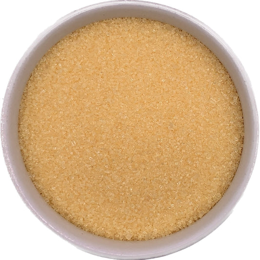Close-up of a bowl filled with yellow sanding sugar, showcasing its fine texture and vibrant color.