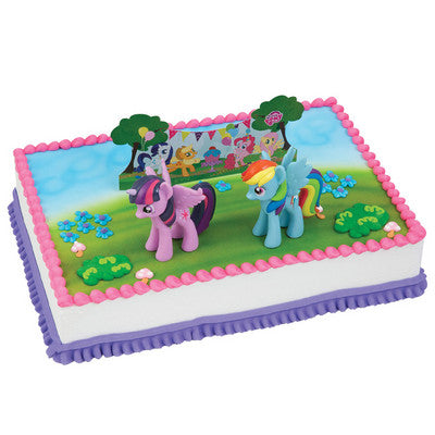 Enchanting rectangular cake adorned with figures of fantasy ponies in a magical meadow setting, complete with lush icing grass and bright floral details, suited for children's fantasy or animal-themed parties.