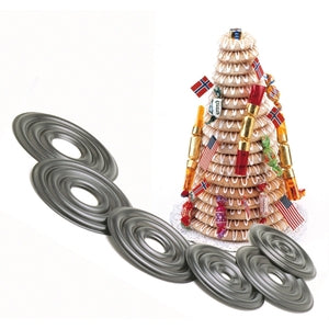 Finished kransekake tower decorated with white icing loops and small flags beside the gray concentric baking rings; traditional Norwegian wreath cake mold set.