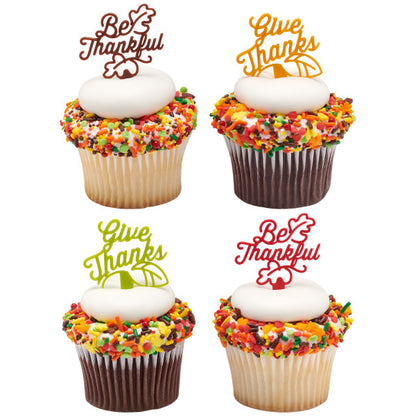 Cupcakes topped with fall sprinkles and colorful Thanksgiving picks that say “Give Thanks” and “Be Thankful.”