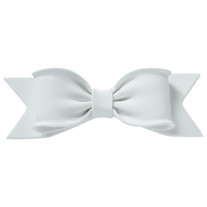 Front view of a large white gum paste bow with realistic folds and ribbon tails, designed for cake decorating.